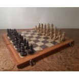 Carved soapstone chess set, pawns 3.8cm high, queens 6.5cm high and a wooden framed tiled folding