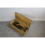 A slatted pine box containing various vintage tools, including spoke shaves, Surform rasp, cleavers.