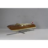 A modern model of a vintage Italian teak speed boat, displayed on a chromed stand 19cm x 64cm x