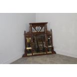 A late Victorian mahogany over-mantel mirror, with bevelled mirror plates, turned columns and carved