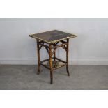 A Victorian bamboo occasional table with painted and lacquered top and under-tier. top damaged