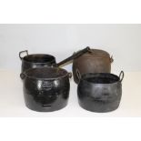 A group of four antique cast-iron pans, one with applied label '11 Kendrick 2 gallon' , one marked