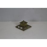 A Victorian cast-brass inkstand, with finial topped hinged cover and floral and mask cast border