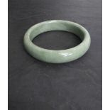 A circular green stone (Jade type) bangle 7.5cm diameter