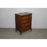 A reproduction burr-walnut bachelors chest, with moulded and slightly bowed quarter veneered top