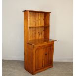 A country made yewwood dresser, the back with single shelf over the shaped top and two cupboard
