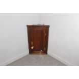 A George III oak corner cupboard with panelled door and brass H-form hinges 97cm x 63cm x 32cm