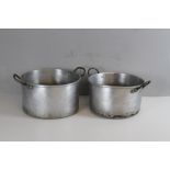 Two large aluminium two-handled cooking pans 35cm & 32cm one slightly misshaped.