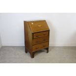 An Edwardian inalid mahogany bureau, of small proportions. The fall front inlaid with conch shell