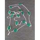 A white metal and emerald necklace with facet cut pear shaped links, 54cm