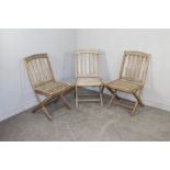 A group of three teak folding garden chairs, weathered. 84cm
