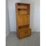 A 1970's G-plan teak room unit with central bureau section 190cm x 81cm x 46cm