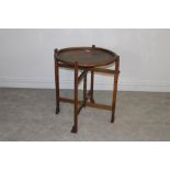 A 1930's oak 'Revertable' card table with circular top and folding base 72.5cm x 61cm