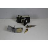 A Kodak Kodette III camera, a chrome cigarette case, carved bone skewer and two metal plumb weights