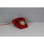 A vintage style rotary telephone, in red plastic