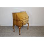 A early-mid 20th century walnut veneered bureau, the fall-front over two drawers and cabriole type