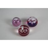 An Alum Bay (Isle of White) purple paperweight and two CG Caithness paperweights