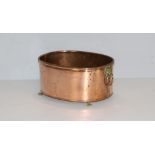 An oval copper planter, with rolled rim and attached lion mask handles and paw feet 14cm x 29cm x