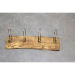 Four metal coat hooks mounted to a rustic wood plinth 62cm x 16cm