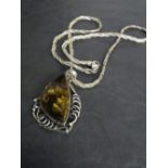 A white metal mounted amber pendant of stylised form, suspended by a rope-twist chain marked 925 ,