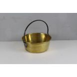 An antique brass jam pan with rolled rim and over-handle 31cm dia