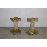 A Pair of stone bird baths/tables, one of dished square section form, raised on a square section