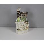 A 19th century Staffordshire pottery flat-back figure group, modelled as a goat standing over a