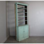 A 19th century blue-painted pine bookcase over cupboard, with moulded cornice over four open