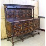 A large 1930's carved oak sideboard, in the Jacobethan style, with dentil surmount, nulled frieze,