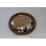 A 1920's grained(simulated) oval wall mirror 50cm x 61cm