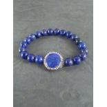 A Lapis Lazuli spherical bead bracelet, the central disk bead inset with white stones 7cm diameter