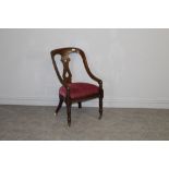 A Victorian mahogany armchair, with central vase-form supporting splat and down-swept arms over