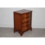 A reproduction mahogany chest of drawers, the serpentine fronted top above four cockbeaded