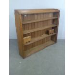 An oak and pine four tier open bookcase with short three-quarter gallery, shaped feet damaged but