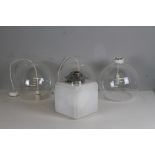 A set of three clear globular glass light shades and electrical fittings 29cm diameter sold along
