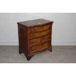 A reproduction figured mahogany chest of drawers, with serpentine fronted top over four graduating