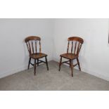 A pair of 19th century stained -beechwood kitchen chairs, with concave crest rail over turned