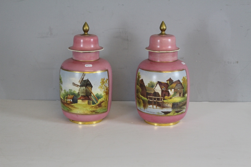 A pair of Continental porcelain lidded urns, each enamelled to front with named views, worded