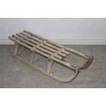 A vintage Davos sledge with slatted seat and iron mounted runners 106cm