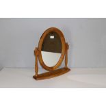 A modern pine swing toilet mirror, of typical form with oval plate 47cm