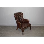 A brown leather deep-buttoned Chesterfield armchair 82cm