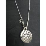 A 925 grade white metal pendant and chain, the circular textured pendant marked 925, 1.5cm x the
