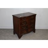 A reproduction figured mahogany chest of drawers, with serpentine fronted top over four graduating