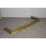 A Victorian brass fender, with scrolled detail between tube and ball rails, moulded base 52cm