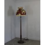 A mahogany standard lamp, with turned column, disk base and turned feet. Floral tasseled material