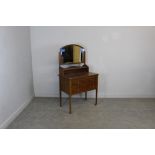 An Edwardian mahogany dressing table, with arched and bevelled plate over raised shelf and two