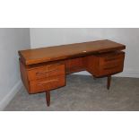 A G-Plan teak desk/dressing table/sideboard with floating top above the central knee-hole and