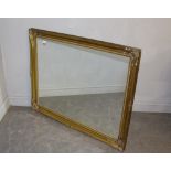 A large modern mirror, within a gilt swept frame 90cm x 115cm generally good, some minor marks to