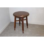 An early 20th century oak bar table, in the Arts & Crafts style, with moulded circular top above