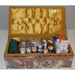 A vintage sewing box and contents, various spools of cotton, buttons, sewing items